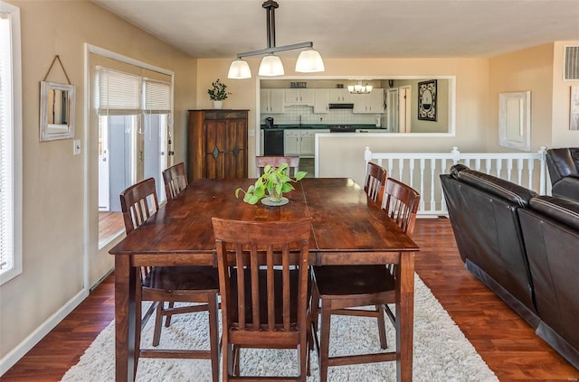 dining area featuring dark wood-type flooring, visible vents, and baseboards