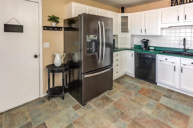 kitchen with black dishwasher, stainless steel fridge, decorative backsplash, white cabinets, and a sink