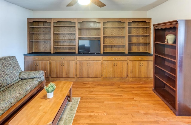 living room with a ceiling fan and light wood-type flooring