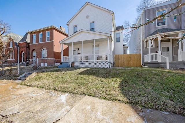 view of front facade with covered porch, fence, and a front yard