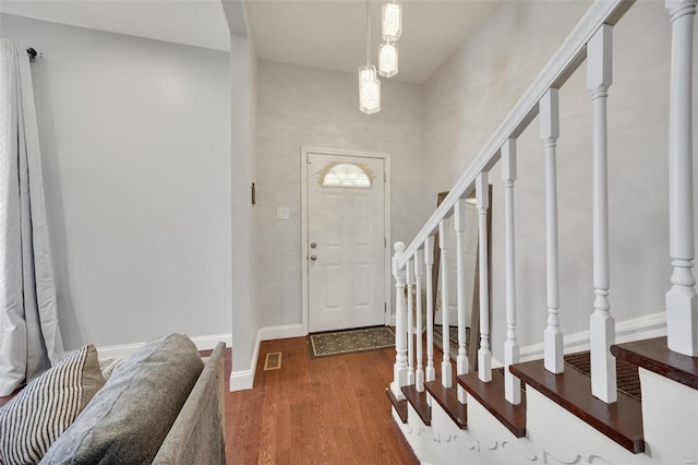 entrance foyer featuring stairs, wood finished floors, visible vents, and baseboards