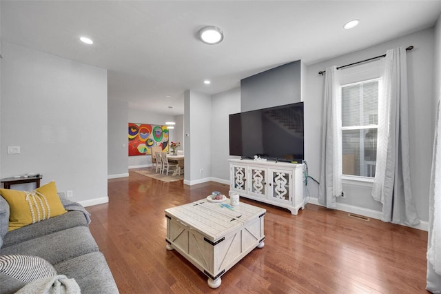 living room with recessed lighting, baseboards, and wood finished floors