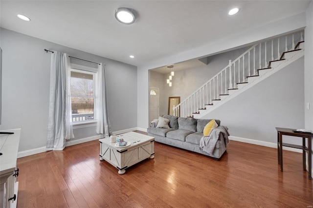 living room featuring recessed lighting, stairway, baseboards, and wood finished floors