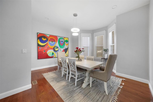 dining area featuring visible vents, baseboards, and wood finished floors