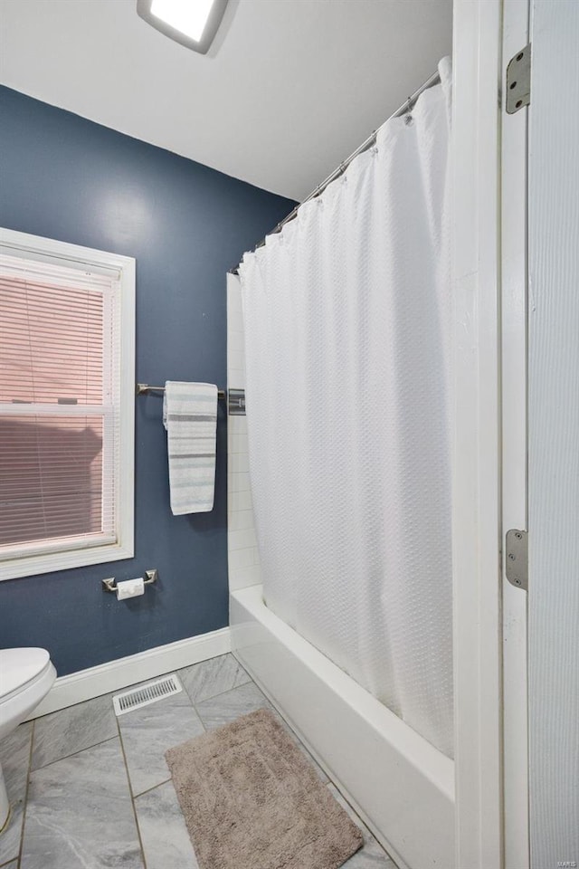 full bath featuring marble finish floor, shower / tub combo with curtain, visible vents, toilet, and baseboards