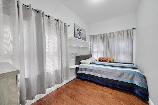 bedroom featuring baseboards and wood finished floors