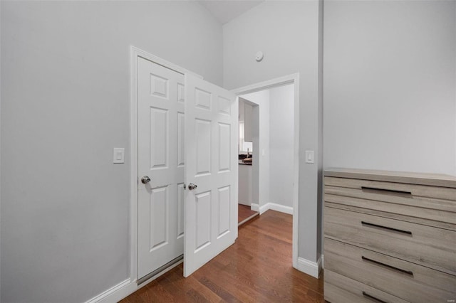 hall featuring baseboards and dark wood finished floors