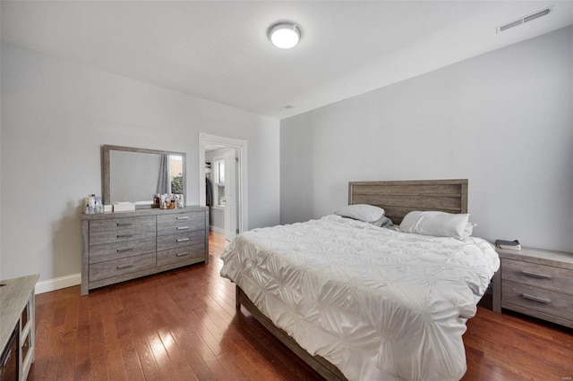 bedroom with baseboards, visible vents, and hardwood / wood-style floors