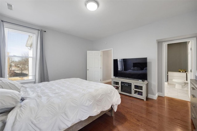 bedroom featuring wood finished floors and baseboards