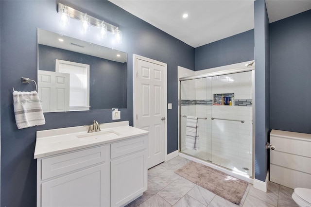 bathroom with marble finish floor, a shower stall, baseboards, and vanity