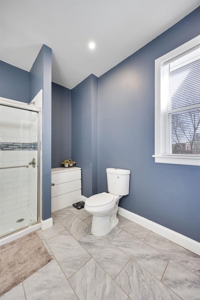 full bathroom featuring a stall shower, marble finish floor, toilet, and baseboards