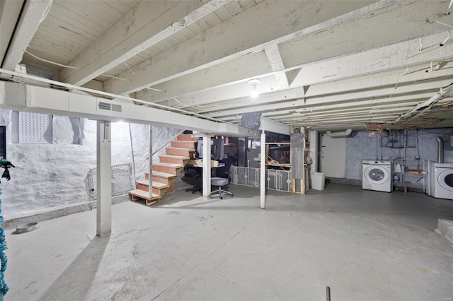 unfinished basement featuring stairway, visible vents, and separate washer and dryer