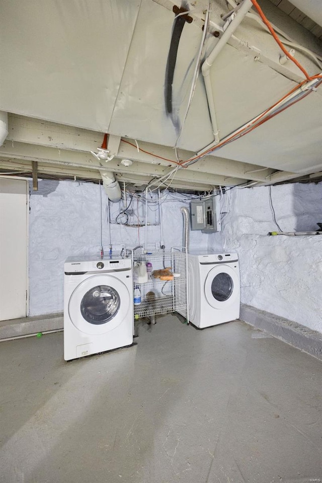 unfinished basement featuring electric panel and washer and dryer