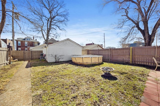 view of yard featuring a fire pit, a fenced backyard, and a fenced in pool