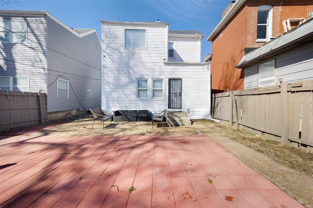 rear view of house featuring entry steps, a fenced backyard, and a wooden deck