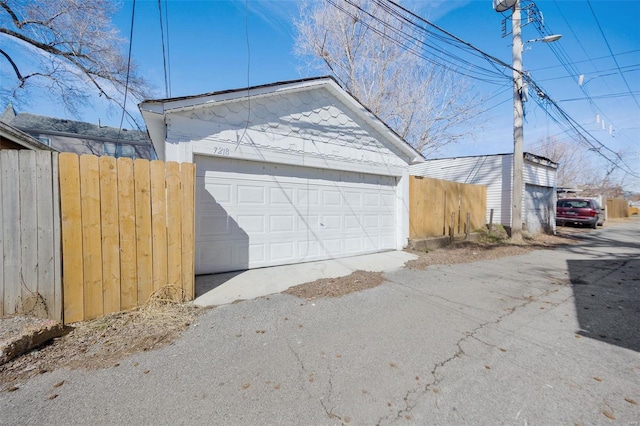 detached garage featuring fence