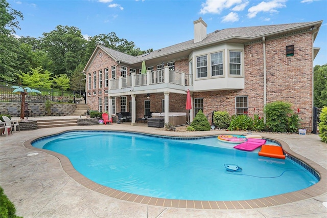 pool with a patio, fence, a ceiling fan, and a hot tub