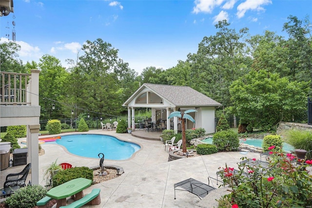 outdoor pool with a storage structure, fence, an outdoor structure, and a patio