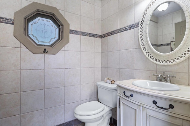 bathroom with tasteful backsplash, tile walls, vanity, and toilet