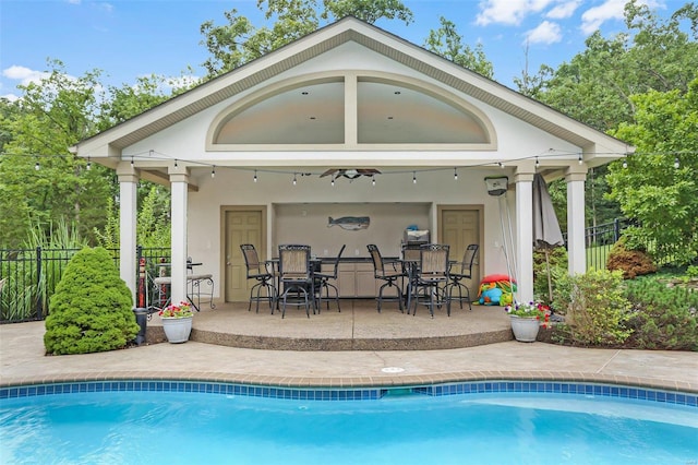 outdoor pool featuring fence and a patio