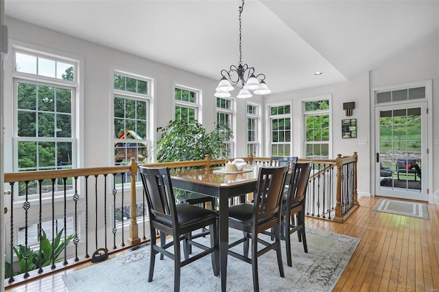 dining area with light wood-type flooring, plenty of natural light, and lofted ceiling