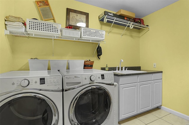 laundry area with light tile patterned floors, a sink, baseboards, cabinet space, and washing machine and clothes dryer