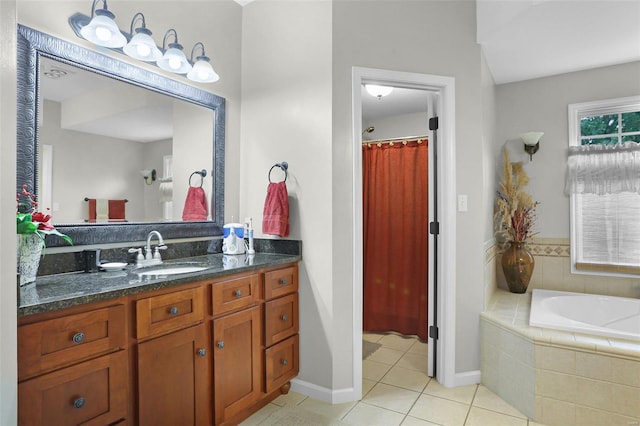 bathroom with tiled bath, tile patterned flooring, vanity, and baseboards