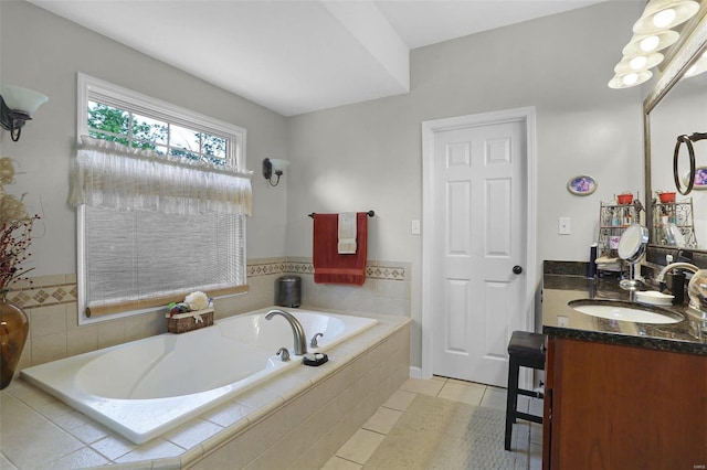 bathroom with tile patterned flooring, a garden tub, and vanity