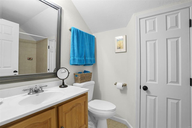 bathroom featuring toilet, vanity, and lofted ceiling