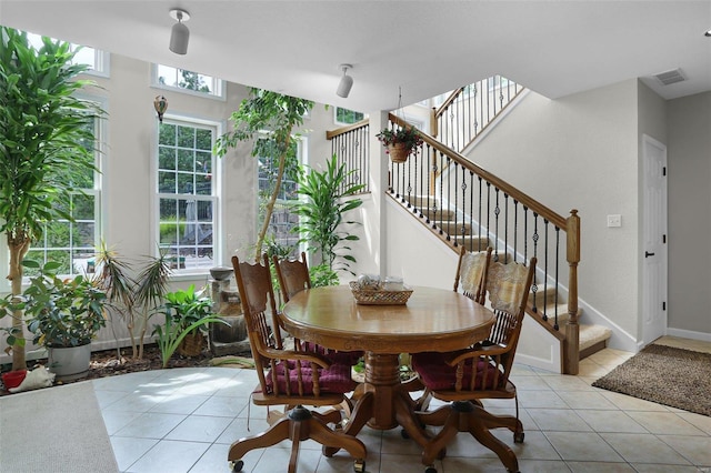 dining space featuring light tile patterned floors, stairs, visible vents, and baseboards