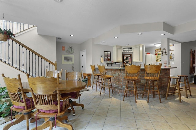 dining room with recessed lighting, stairway, a bar, and light tile patterned floors