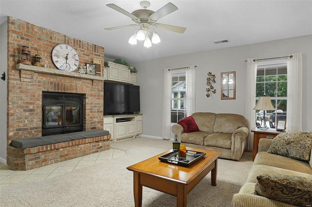 living room featuring a healthy amount of sunlight, a brick fireplace, visible vents, and light colored carpet