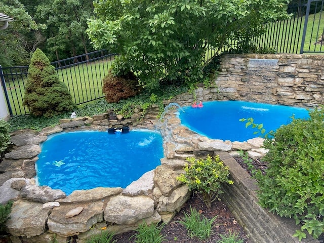 view of pool featuring fence