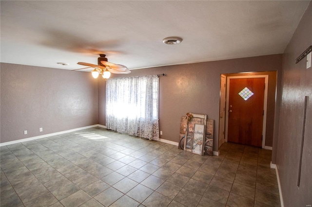 tiled foyer with ceiling fan, visible vents, and baseboards