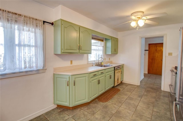 kitchen with green cabinetry, dishwasher, ceiling fan, light countertops, and a sink