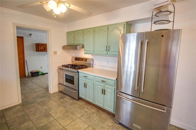 kitchen featuring ceiling fan, under cabinet range hood, green cabinets, light countertops, and appliances with stainless steel finishes