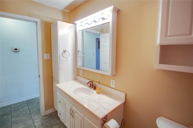 bathroom featuring toilet, baseboards, vanity, and tile patterned floors