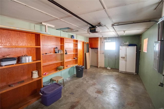 interior space with white fridge with ice dispenser, electric panel, and a garage door opener