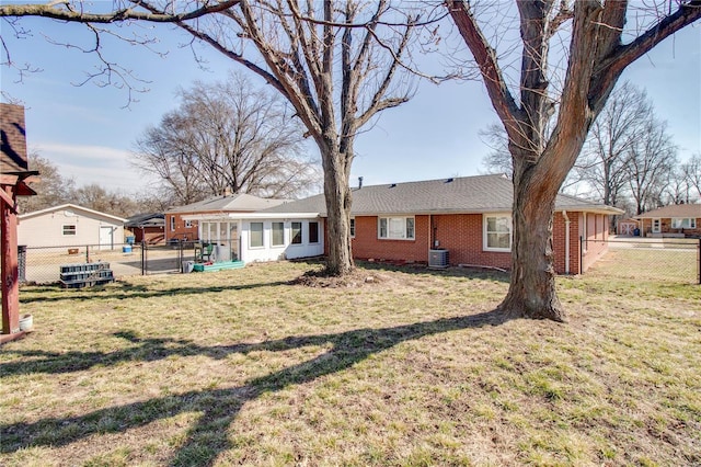 rear view of property with a yard, a fenced backyard, cooling unit, and brick siding