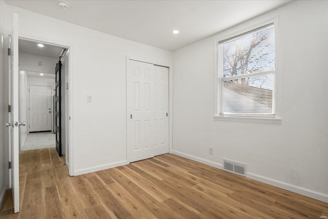 unfurnished bedroom featuring light wood finished floors, baseboards, visible vents, and recessed lighting