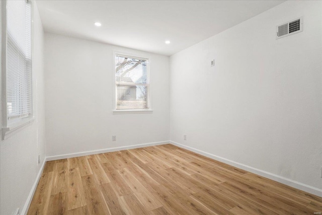 unfurnished room with recessed lighting, visible vents, light wood-style flooring, and baseboards