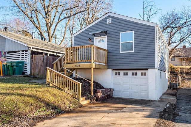 view of front of property featuring a garage, concrete driveway, fence, and stairs