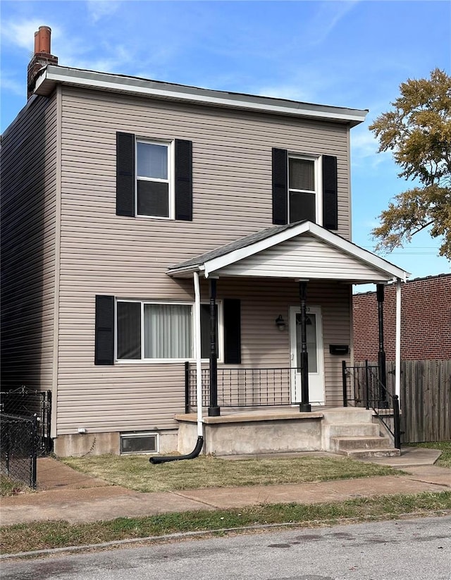 traditional-style home with covered porch and fence