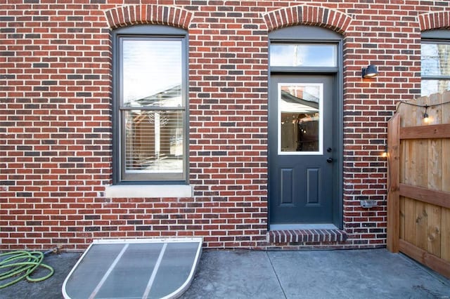 view of exterior entry with brick siding