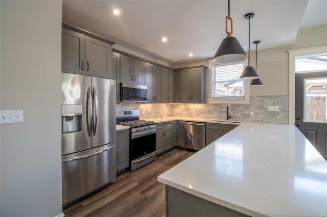 kitchen with stainless steel appliances, a wealth of natural light, a sink, and gray cabinetry