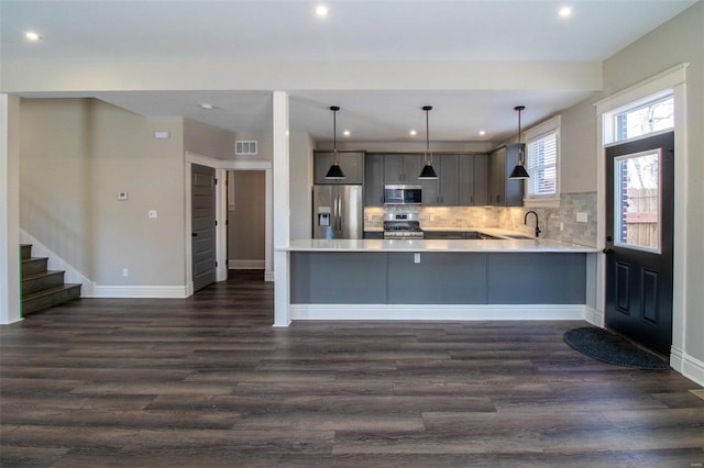 kitchen featuring gray cabinetry, stainless steel appliances, a sink, visible vents, and light countertops