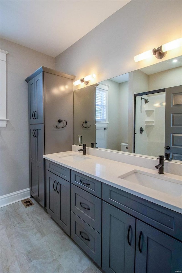 bathroom featuring double vanity, a sink, visible vents, and a shower stall