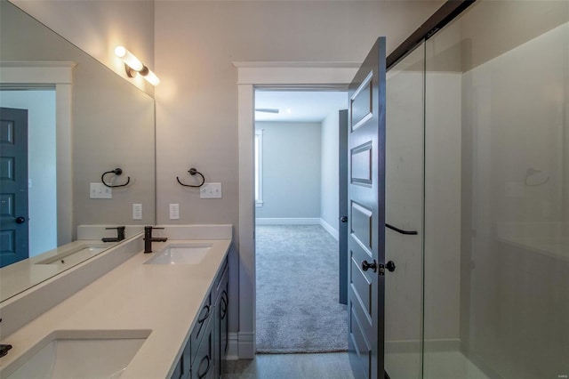 bathroom with walk in shower, a sink, and double vanity