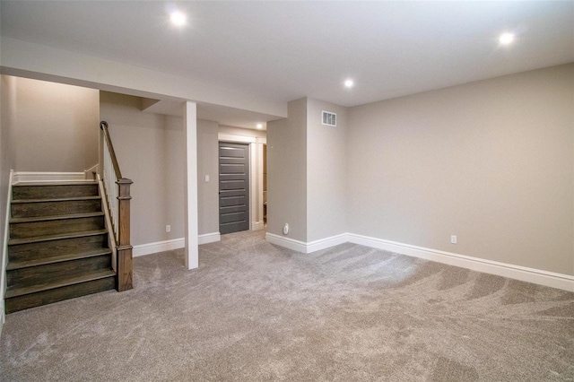 finished basement featuring baseboards, stairs, and visible vents