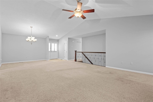 carpeted empty room with lofted ceiling, visible vents, baseboards, and ceiling fan with notable chandelier